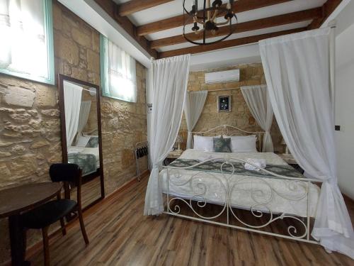 a bedroom with a bed and a table and a mirror at Hotel Valide Hanim Konak in Lefkosa Turk