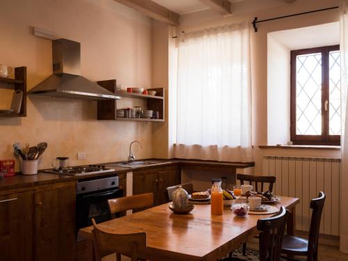 a kitchen with a wooden table and a dining room at La Guest House della Tenuta di Tavignano in Cervidone