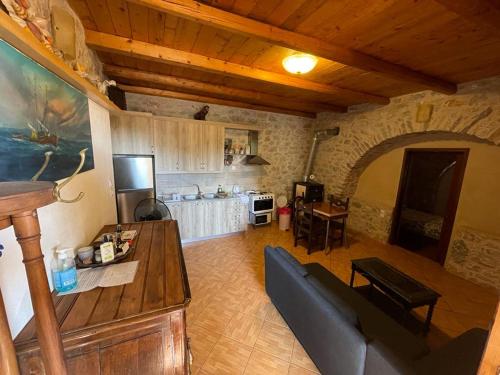 een woonkamer met een bank en een keuken bij Find your peace in a traditional country house!! in Lagia