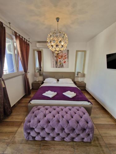 een slaapkamer met 2 bedden en een kroonluchter bij Primera Luxury Studio in Zadar