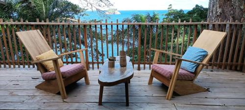 two chairs and a table on a wooden deck at Tribal Green Camp-Private Room 3 in Santana