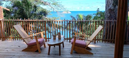 - une terrasse couverte avec 2 chaises, une table et une clôture dans l'établissement Tribal Green Camp-Private Room 3, à SantʼAna