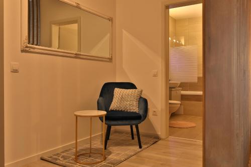 une chaise noire et un tabouret dans le couloir avec un miroir dans l'établissement Ada Homes B46, à Braşov