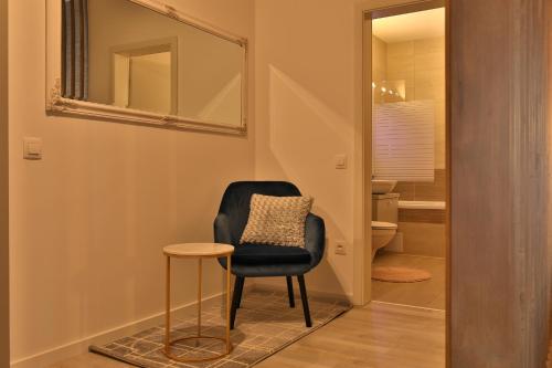 a black chair and stool in a hallway with a mirror at Ada Homes B46 in Braşov