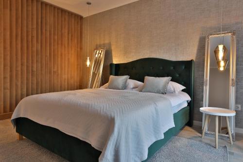 - une chambre avec un grand lit et une tête de lit verte dans l'établissement Ada Homes B46, à Braşov