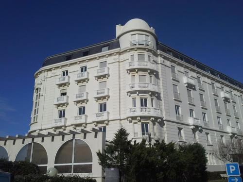 a large white building with balconies on the side of it at Appartement avec vue exceptionnelle sur Biarritz in Biarritz