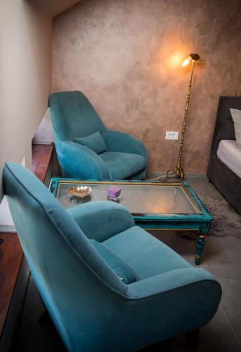 a living room with a blue chair and a table at Čista desetka! - sa garažnim mestom in Novi Sad