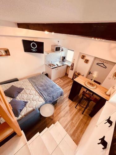 une chambre avec un lit et une table dans une pièce dans l'établissement Charmant studio rénové et équipé, à Hettange-Grande