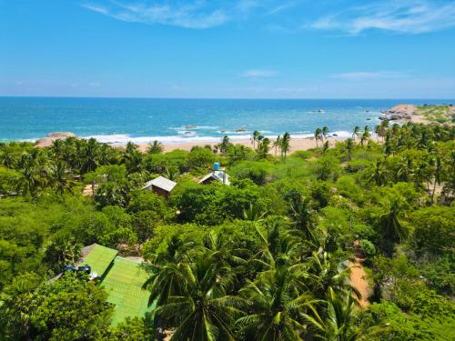 an aerial view of a beach with palm trees and the ocean at Sarada Beach Resort Yala in Tissamaharama