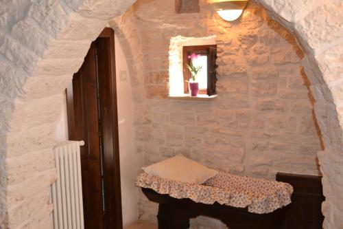 a room with a table in a stone wall at Trulli Aia Piccola in Alberobello