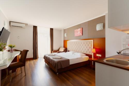 a bedroom with a bed and a kitchen with a sink at Hotel 19 Batumi in Batumi