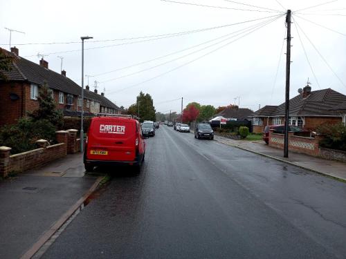 una furgoneta roja estacionada al lado de una calle en Byron View House, en Luton