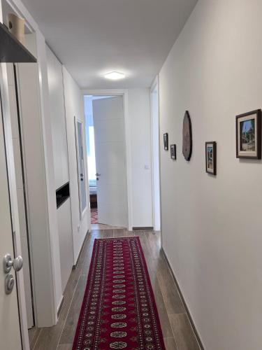 a hallway with a red rug on the floor at SkyView Apartment in Sarajevo