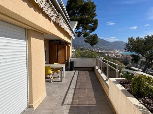 - un balcon d'une maison avec une table et des chaises dans l'établissement Superbe appartement vue imprenable sur la mer proche Monaco, à Roquebrune-Cap-Martin
