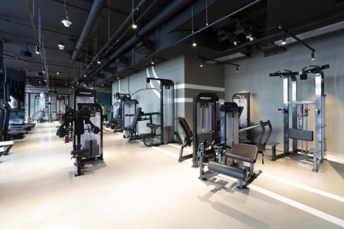 un gimnasio con filas de cintas de correr y máquinas en Marquise Square - 2Br Apartment - Allsopp&Allsopp, en Dubái