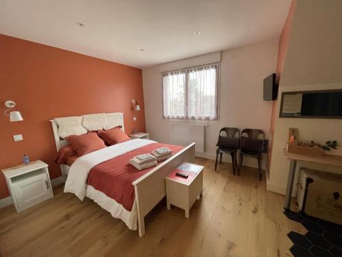 ein Schlafzimmer mit einem großen Bett mit orangefarbenen Wänden in der Unterkunft Chambre proche centre avec petit déjeuner in Fontaine-lès-Dijon