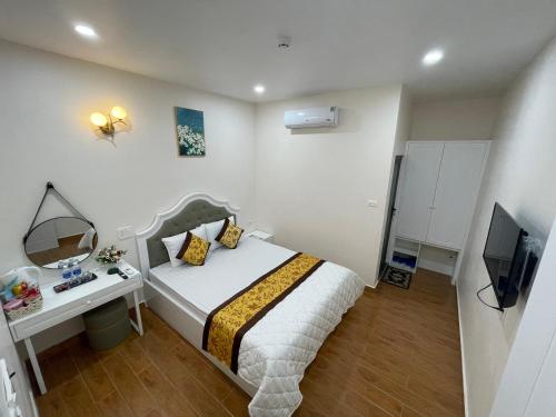 1 dormitorio con cama, espejo y TV en Thinh Gia Hotel, en Bến Cát