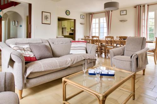 a living room with a couch and chairs and a table at Vacances en famille ou entre amis à Loctudy in Loctudy