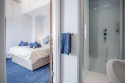 a bedroom with a bed and a glass shower at Ocean Cabins No 11 At The Square - Saundersfoot in Saundersfoot