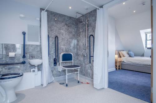 a bathroom with a shower and a toilet and a sink at Ocean Cabins No 10 At The Square - Saundersfoot in Saundersfoot