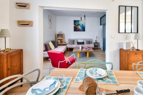 un salon avec une table et des chaises et un salon dans l'établissement Jolie maison pour 6 à Noirmoutier-en-l'Ile, à Noirmoutier-en-l'lle