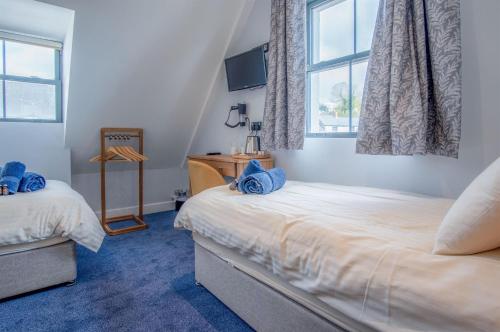 a bedroom with two twin beds and a window at Ocean Cabins No 10 At The Square - Saundersfoot in Saundersfoot