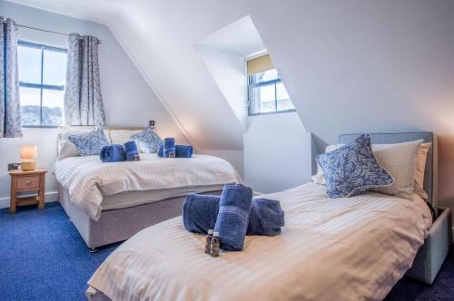 a bedroom with two beds with blue carpet at Ocean Cabins No 9 At The Square - Saundersfoot in Saundersfoot