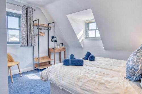 a bedroom with a bed with blue pillows on it at Ocean Cabins No 14 At The Square - Saundersfoot in Saundersfoot