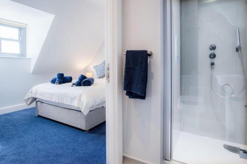 a bedroom with a bed and a glass shower at Ocean Cabins No 14 At The Square - Saundersfoot in Saundersfoot