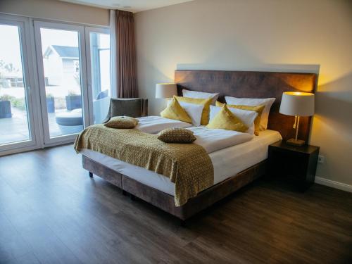 a bedroom with a large bed and a large window at Strandhotel Luv in Timmendorfer Strand