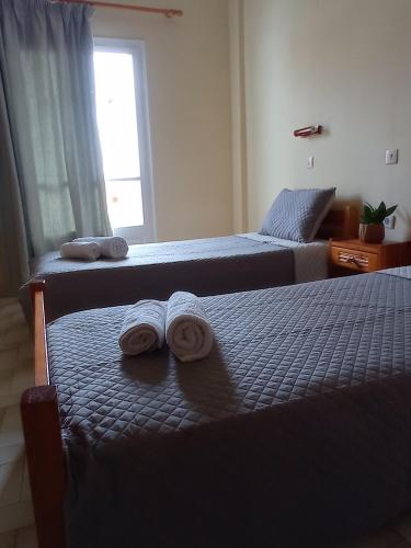 two beds in a bedroom with towels on them at Hermes in Kavos