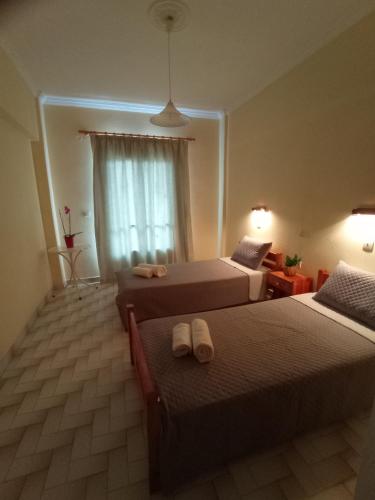 a hotel room with two beds and a window at Hermes in Kavos