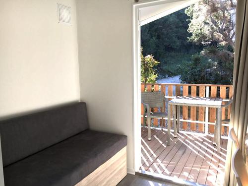 Habitación con puerta corredera de cristal que da a una terraza. en Camping Village La Sorgente, en Portoferraio