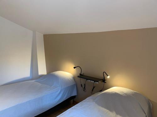 Un dormitorio con dos camas y un estante en la pared. en gîtes du Cady, en Casteil