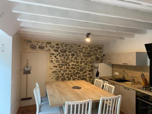 a kitchen with a wooden table and white chairs at gîte du Cady in Casteil