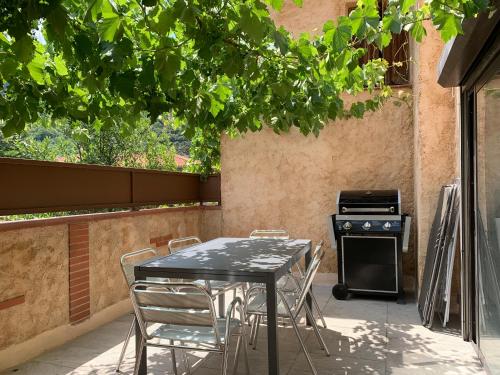 una mesa y sillas en un patio con fogones en gîtes du Cady, en Casteil