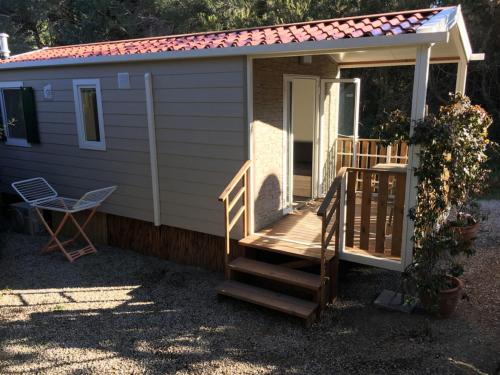 a tiny house with a staircase and a porch at Camping Village La Sorgente in Portoferraio