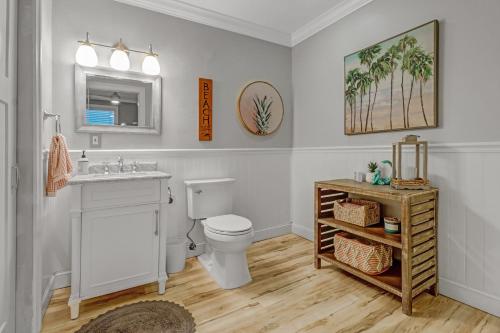 a bathroom with a toilet and a sink and a mirror at Coastal Soul House in the heart of Naples in Naples