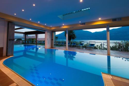 a swimming pool in a house with a view of the water at Hotel Eden in Brenzone sul Garda