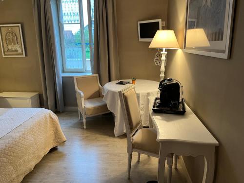 une chambre d'hôtel avec une table, des chaises et un lit dans l'établissement Chez Elodie, à Pressigny