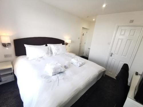 a bedroom with a white bed with two towels on it at The Kerswell Hotel in Morecambe