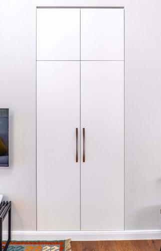 a white cupboard in a living room at TIFLIS OPERA Aparthotel in Tbilisi City