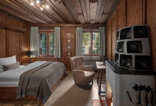 um quarto com uma cama, uma cadeira e uma secretária em Hotel Goldener Greif em Kitzbühel