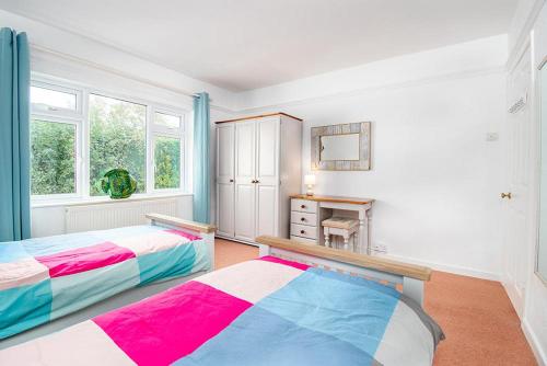1 dormitorio con 2 camas y mesa. en Greenacres, en Llanbedrog