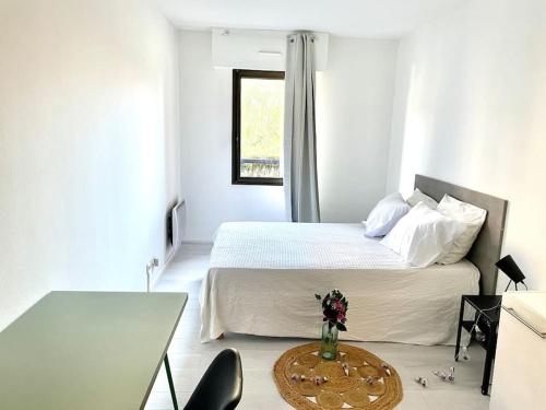 - une chambre blanche avec un lit, une table et un sidx de table dans l'établissement Chez Sandra et Rach, à Toulouse