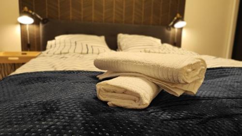 a bed with two towels sitting on top of it at Lenki apartamenty Białołęka in Warsaw