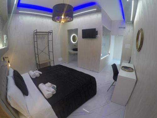 LE CAMERE Luxury Rooms SIRACUSA في سيراكوزا: غرفة نوم بسرير اسود وحمام