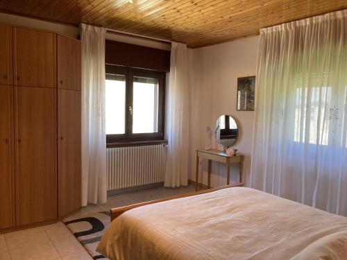 a bedroom with a bed and a window and a mirror at Appartamento Il Giardino in Castello dellʼAcqua