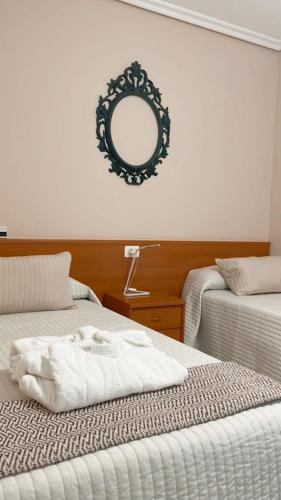 a room with two beds and a mirror on the wall at Casa Pazos, Pedrafita do Cebreiro in Piedrafita