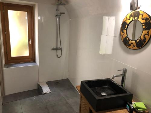 une salle de bain avec un lavabo et un miroir au mur dans l'établissement Apt de charme sur la Marina de Bonifacio, à Bonifacio